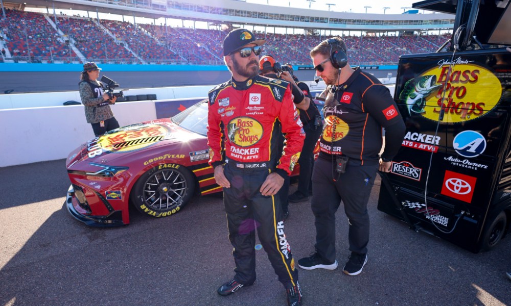 NASCAR driver beside red racing car