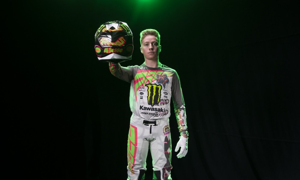 Man holding green motocross helmet