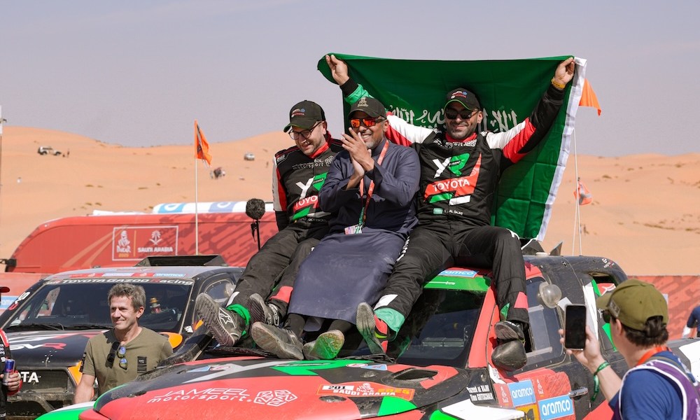 Men celebrate on race car hood