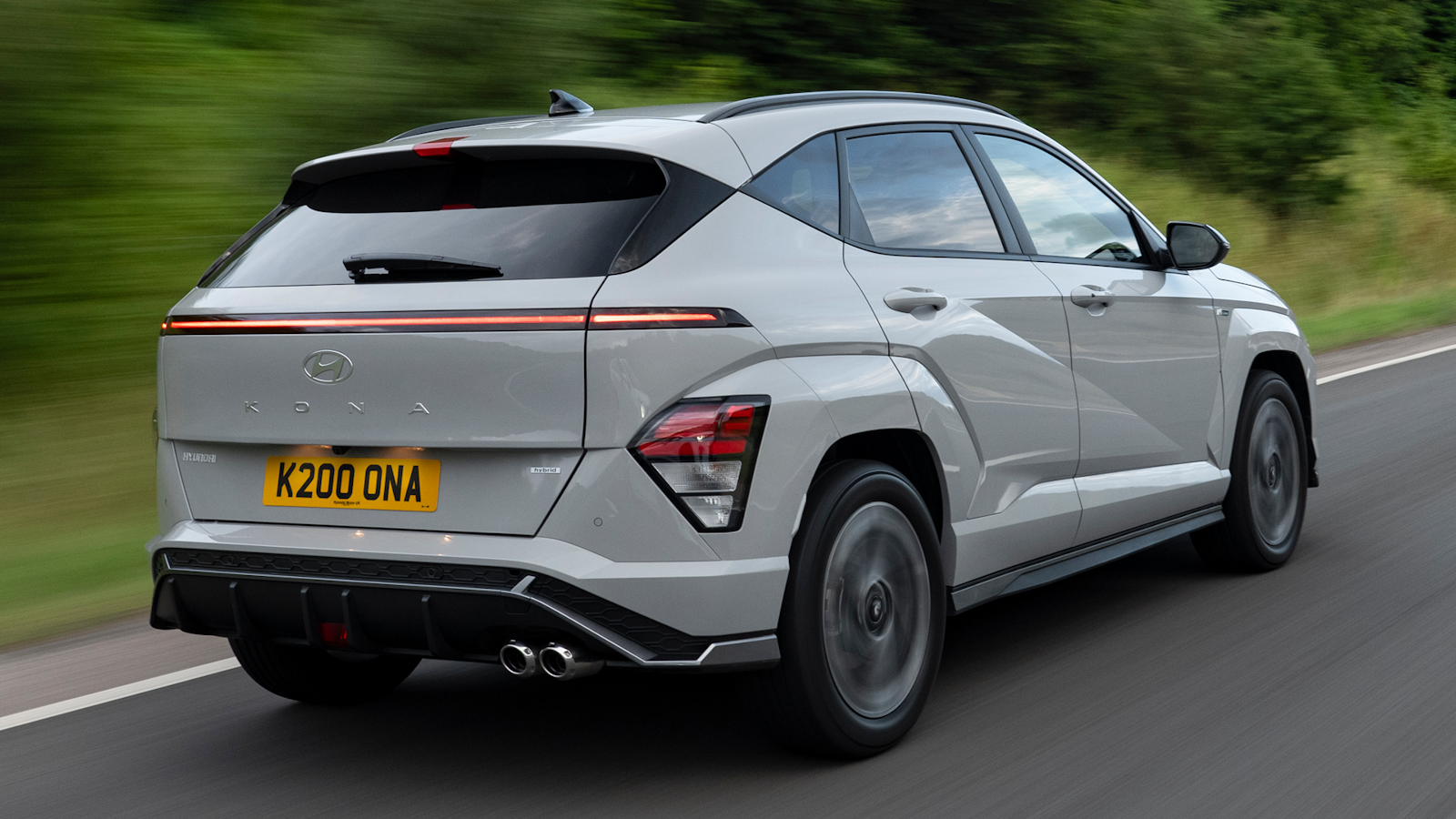 White Hyundai Kona driving from rear