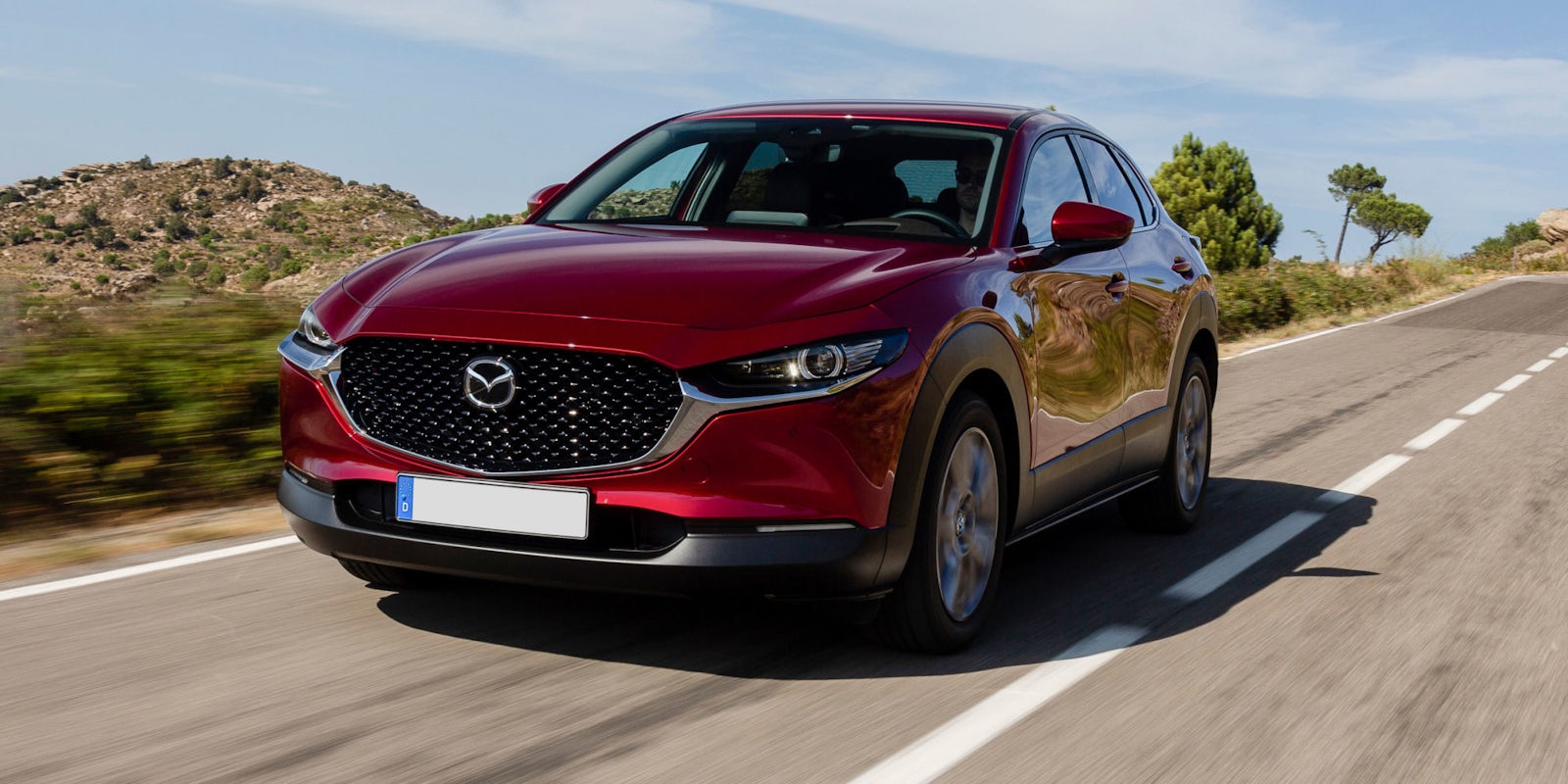 Red Mazda CX-30 driving front view