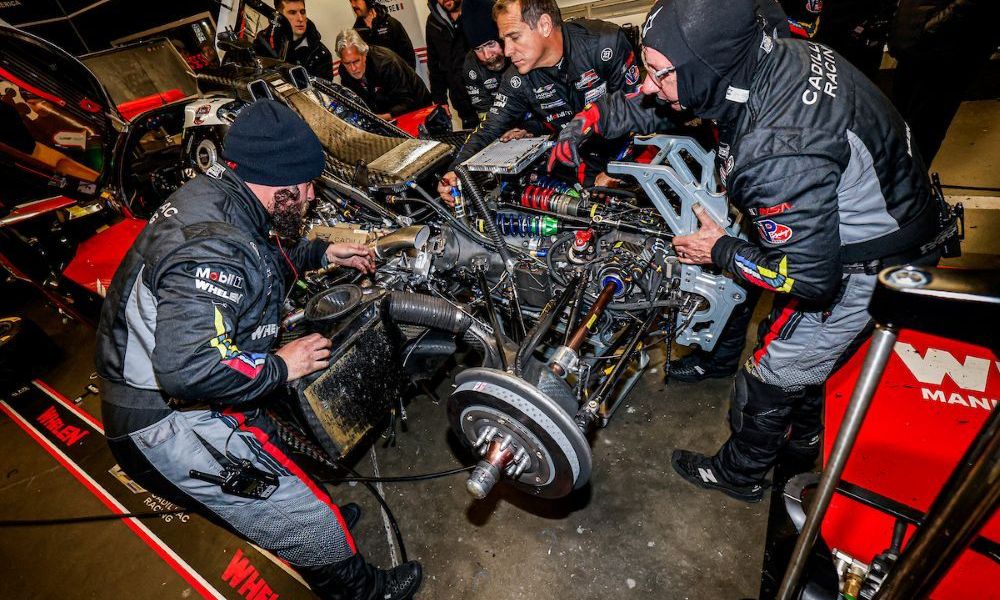 Mechanics servicing race car during IMSA