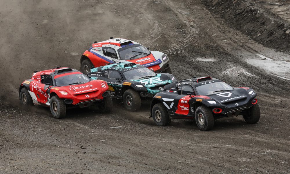 Four cars compete on dirt track