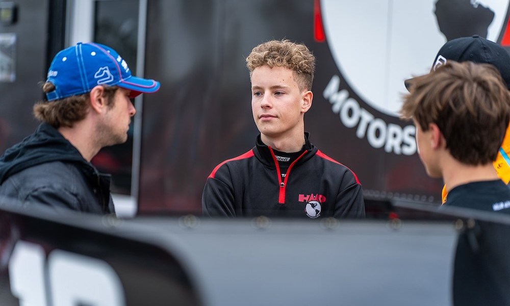 Three men inspect racing car