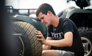 Chase McDermand inspects race car tire