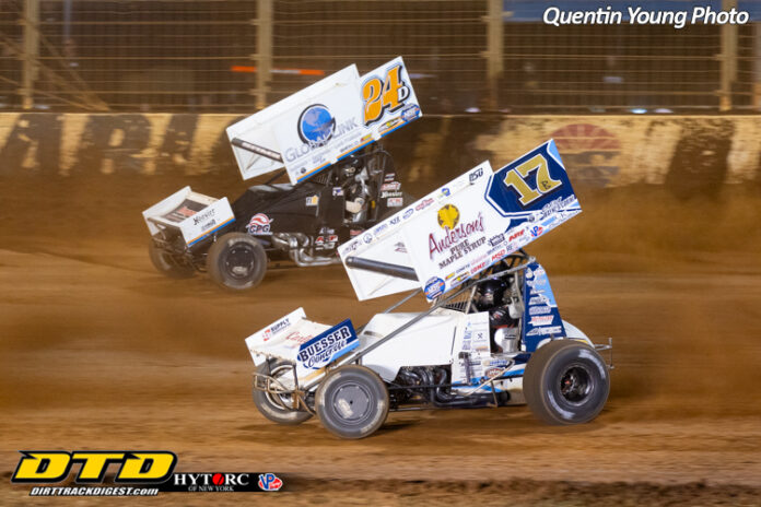 Two sprint cars racing dirt track