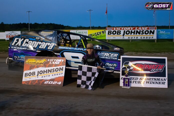 Man waves checkered flag at racetrack