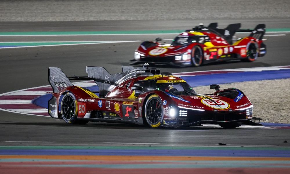 Two red Ferraris racing side-by-side