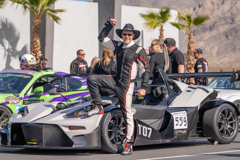 Racer posing with racing car