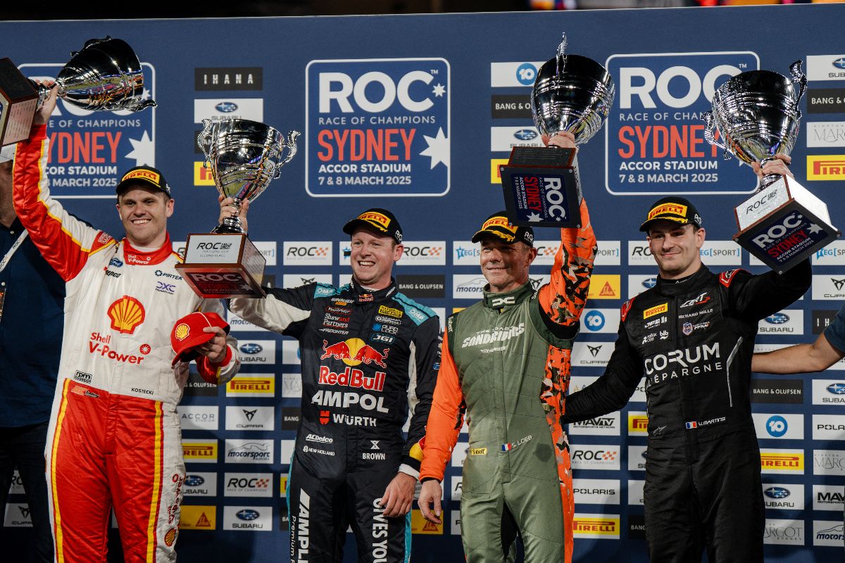 Four racers celebrating with trophies